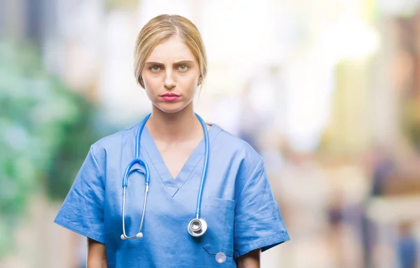 年轻美丽的金发医生护士妇女在孤立的背景怀疑和紧张 皱着眉头不安的问题 消极的人 — 图库照片