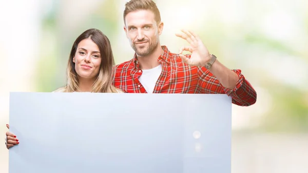 Pareja Joven Junta Sosteniendo Banner Blanco Sobre Fondo Aislado Haciendo —  Fotos de Stock