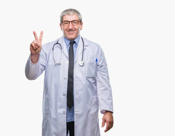 英俊的资深医生在孤立的背景显示和指向用手指第二 同时微笑着自信和快乐 — 图库照片