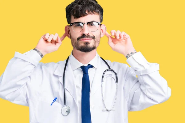 若い医者と指 面白いジェスチャー分離背景笑顔引き耳の上病院コートを着た男 オーディションの問題 — ストック写真