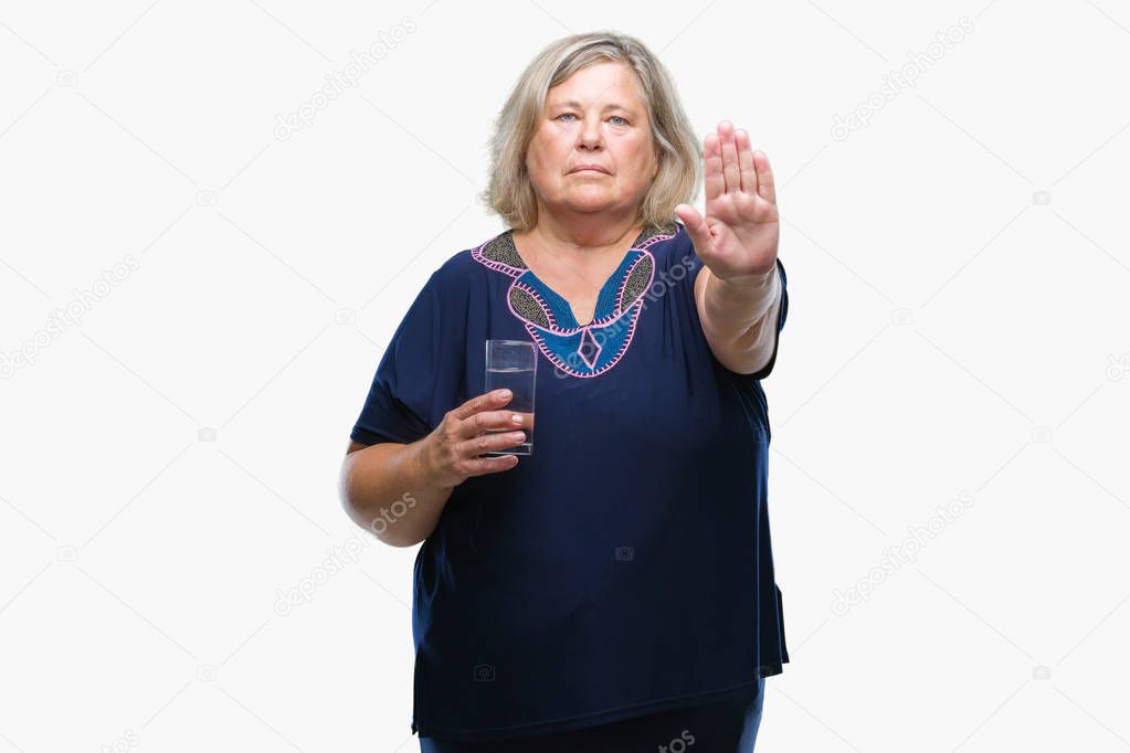Senior plus size caucasian woman drinking glass of water over isolated background with open hand doing stop sign with serious and confident expression, defense gesture