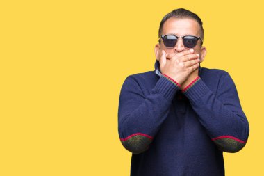 Orta yaş Arap adam üzerinde güneş gözlüğü takıyor arka plan ağız hata için elleriyle kapsayan şok izole. Gizli kavramı.