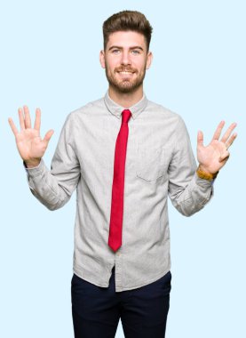Gösterilen ve parmakları ile işaret genç yakışıklı iş adamı numara 9 kendinden emin ve mutlu gülümseyerek süre.