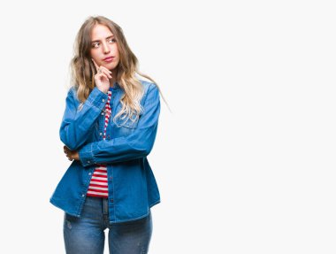 Güzel sarışın genç kadın elle çene düşünme hakkında soru, dalgın ifade izole arka plan üzerinde. Düşünceli yüzüyle gülümsüyor. Şüphe kavramı.