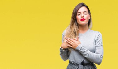 Genç güzel işçi iş kadın kapalı gözler ile göğüs ellerinde ve yüzünde minnettar jest ile gülümseyen izole arka plan yüzünden. Sağlık kavramı.