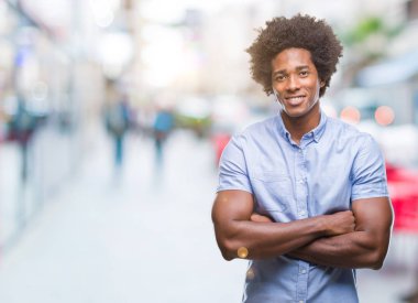 Kameraya bakarak çapraz silah ile gülümseyen izole arka plan mutlu yüzüne Afro Amerikalı adam. Olumlu bir kişi.