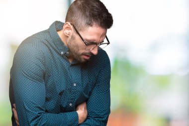 Üzerinde gözlük takan genç yakışıklı iş adamı izole mide üzerinde el ile arka plan çünkü mide bulantısı, ağrılı hastalık hasta hissediyor. Ağrısı kavramı.