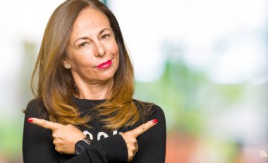 Rock'n roll kazak giyen güzel orta yaş kadın her iki parmak ile işaret eden, farklı yönde katılmıyorum