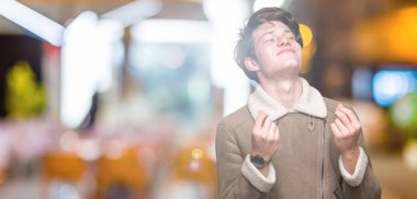 Maaş ödeme için milyoner iş soran izole arka plan yapıyor para hareketi el ile üzerinden kış ceket giyen genç yakışıklı adam