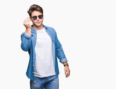Genç yakışıklı adam giyen güneş gözlüğü izole arka yapıyor İtalyan üzerinde el ve parmak emin ifadeyle jest