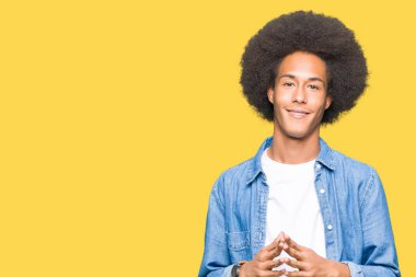 Afro saç el ele tutusun genç Afro-Amerikan adamla ve parmakları rahat ve neşeli gülümseyen geçti. Başarı ve iyimser