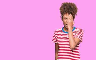 Güzel genç Afro-Amerikan kadın yarım yüz, göz ve ağız el ile kapsayan yorgun esneme izole arka plan yüzünden. Acı yüzü acıyor.