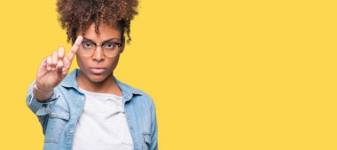 Güzel genç Afro-Amerikan kadın gözlük izole üzerinde arka plan işaret parmağını ve kızgın ifade ile