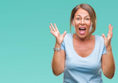 Orta yaş üst düzey İspanyol kadın yüzünden kızgın ve silah ile başarı için deli kutluyor izole arka plan ortaya çıkar ve heyecanlı çığlık gözler kapalı. Kazanan kavramı