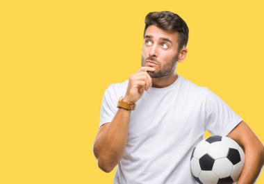 Yakışıklı delikanlı izole arka plan ciddi bir yüz düşünme hakkında soru, çok karışık bir fikir üzerinde futbol futbol topu tutan
