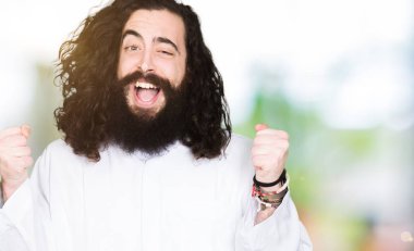 İsa Mesih kostüm kutluyor giyen adam şaşırttı ve silah ile başarı için yükseltilmiş ve açık gözler hayrete düşürdü. Kazanan kavramı.