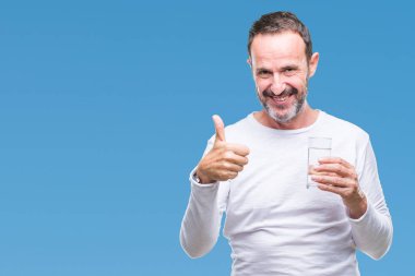 Orta yaş ağarmış komuta sizde ok işareti, başparmak ile parmak, mükemmel işareti yapıyor kocaman bir gülümseme ile izole arka plan üzerinde mutlu bardak su içme