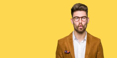 Genç yakışıklı iş adamı giyen dudaklı, çılgın ve komik bir jest yapma balık yüz gözlük. Komik ifade.