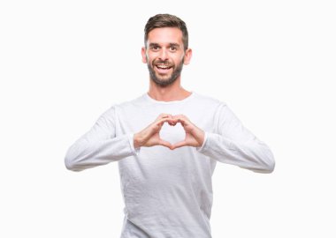 Yakışıklı delikanlı aşık kalp simgesi ve elleriyle şekil gösteren gülümseyen izole arka plan üzerinde. Romantik kavramı.