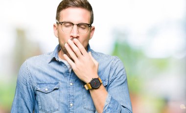 Yakışıklı adam gözlüklü el ağzıyla kapsayan yorgun esneme sıkılmış. Restless ve uyku hali.