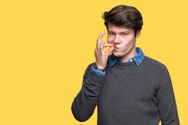 Genç yakışıklı zarif adam izole arka plan ağız ve dudaklar üzerinde parmak ile ZIP olarak kapatın. Gizli ve sessiz, tabu söz