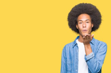 Afrikalı-Amerikalı genç afro saçlı bir öpücük el ile güzel ve seksi olmak hava üfleme kamera bakıyor. Aşk ifade.