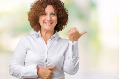 Seyir ve başparmak yanında yukarıyı mutlu yüz ile gülümseyen izole arka plan güzel orta ager üst düzey businees kadın.
