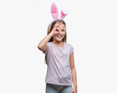 Paskalya bunny kulaklar gülümseyerek el parmakları ile mutlu yüz üzerinden seyir göz ile ok jest yapıyor izole arka plan üzerinde giyen genç güzel kız.