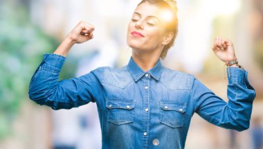 Genç güzel kadın kol kasları gururlu gülümseyen gösterilen izole arka plan yüzünden. Fitness kavramı.