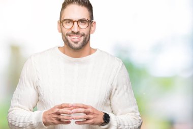 Arka plan eller üzerinde gözlük takan genç yakışıklı adam birlikte izole ve rahat ve neşeli gülümseyen parmak çarpı işareti. Başarı ve iyimser