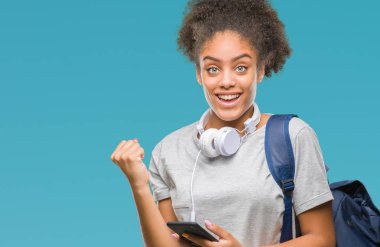 Sırt çantası gurur çığlık ve zafer ve başarı çok heyecanlı, kutluyor izole arka plan üzerinde tutan genç güzel afro Amerikan öğrenci kadın duygu tezahürat