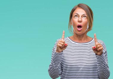 İspanyol kadın kıdemli orta yaş izole arka plan üzerinden hayran ve yukarıya bakıp parmakları ile işaret şaşırttı ve silah kaldırdı.