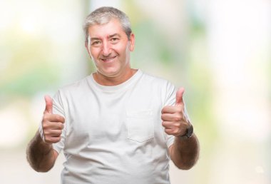 El ile pozitif jest yapıyor izole arka plan başarı işareti üzerinde üst düzey yakışıklı başparmak gülümseyen ve mutlu. Neşeli bir ifadeyle, kazanan jest kameraya bakıyor.