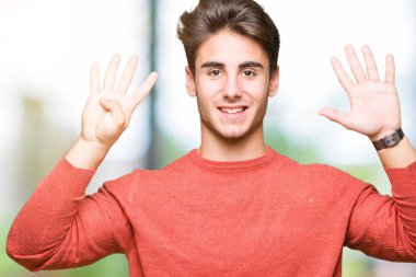 Yakışıklı delikanlı gösterilen ve parmakları ile işaret izole arka plan üzerinde numara 9 kendinden emin ve mutlu gülümseyerek süre.