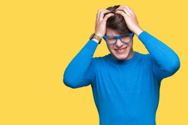 Çünkü çaresiz ve stresli baş ağrısı acı izole arka plan üzerinde mavi gözlük takan genç yakışıklı adam ağrı ve migren. Ellerini kafasına.