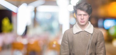 Genç yakışıklı giyen kış ceket sorunu nedeniyle izole arka plan şüpheci ve sinir, papatyanın üzgün üzerinde adam. Negatif kişi.