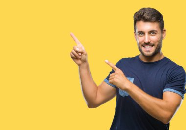 Yakışıklı delikanlı gülümseyen ve iki elleri ve parmakları ile tarafına işaret kamera bakarak izole arka plan üzerinde.