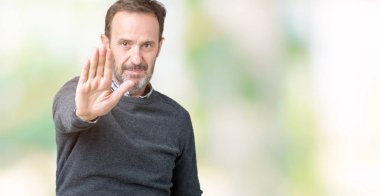 Elin avuç ile şarkı yakışıklı orta yaş komuta sizde dur yapıyor izole arka plan üzerinde bir kazak giyiyor. Negatif ve ciddi bir jest yüz ifadesiyle uyarı.