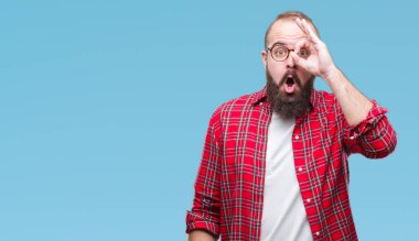 Sürpriz yüz, göz parmaklarının arasından seyir ile ok jest yapıyor izole arka plan üzerinde gözlüklü Genç beyaz hipster adam şok. İmansız ifade.