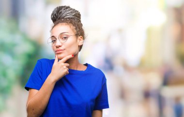 Genç saç Afro-Amerikan Kız emin çapraz kollar ve çeneme kaldırdı el ile gülümseme ile kameraya bakarak izole arka plan üzerinde gözlük takan örgülü. Pozitif düşünce.