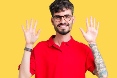 Gösterilen arka plan üzerinde gözlük takan genç yakışıklı adam izole ve parmakları ile işaret kendinden emin ve mutlu gülümseyerek süre on numara.