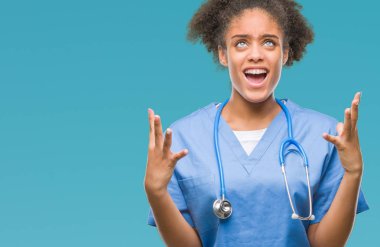 Genç afro Amerikalı doktor kadın izole arka plan çılgın ve kızgın bağırarak ve agresif ifade ve silah kaldırdı bağırıyor. Hayal kırıklığı kavramı.