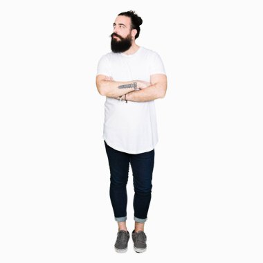 Uzun saç ve sakal gülümseyen geçti silah ile ikna yan seyir ve kendine güvenen rahat beyaz t-shirt giyen genç hipster adamla