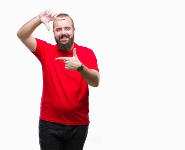 Elle yapma çerçeve ve parmakları ile mutlu yüz gülümseyen izole arka plan üzerinde kırmızı gömlek giymiş genç beyaz hipster adam. Yaratıcılık ve Fotoğrafçılık kavramı.