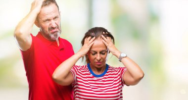 Orta yaş İspanyol çift aşık çünkü umutsuz ve stresli baş ağrısı acı izole arka plan üzerinde ağrı ve migren. Ellerini kafasına.