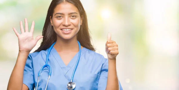 孤立した背景表示と指で上向きに若いアラブ医師外科医女性ナンバー 自信を持って 幸せな笑みを浮かべて — ストック写真