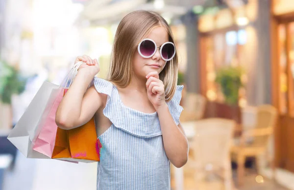 販売に関する質問は 非常に混乱して考え分離背景深刻な顔を考えての上レジ袋を保持している美しい少女 — ストック写真