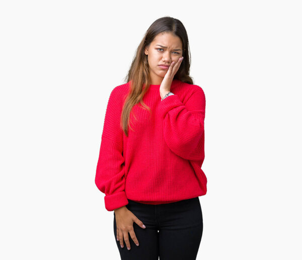 Молодая красивая брюнетка в красном зимнем свитере на изолированном фоне думает усталый и скучно с депрессией проблемы со скрещенными руками
.