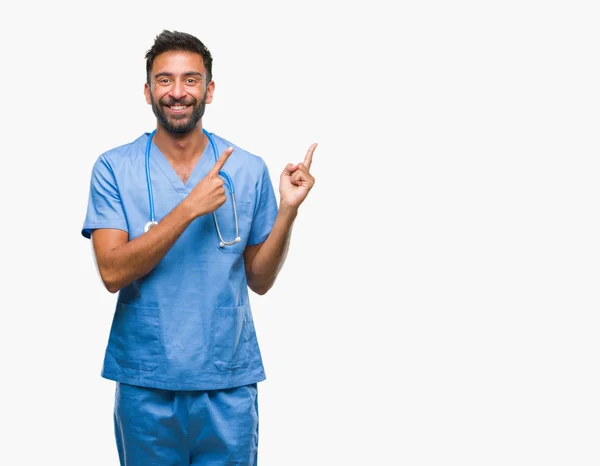 成人西班牙裔医生或外科医生的人在孤立的背景下微笑着 看着相机指着两只手和手指的侧面 — 图库照片