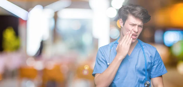 Joven Doctor Vistiendo Uniforme Médico Sobre Fondo Aislado Tocando Boca — Foto de Stock